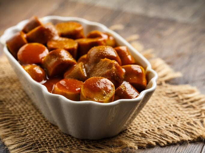 Ein Bild von einem weißen Keramikschale gefüllt mit Berliner Curry-Wurst. | © iStock/ vertmedia
