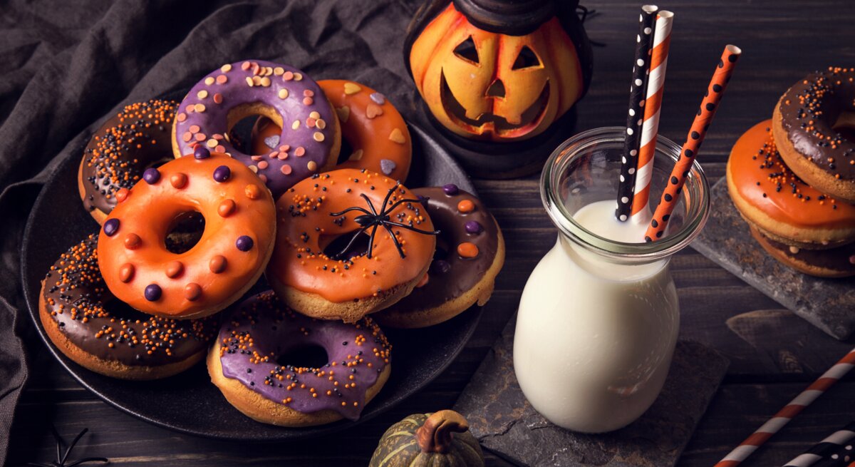 verschieden dekortierte Halloween-Donuts auf einem Teller. 