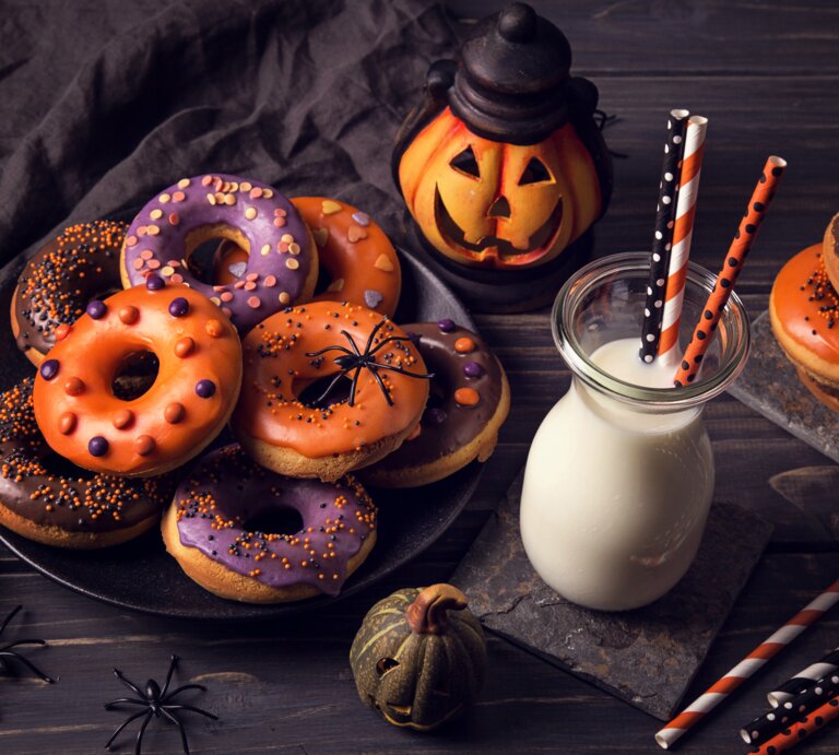 verschieden dekortierte Halloween-Donuts auf einem Teller.  | © iStock / egal