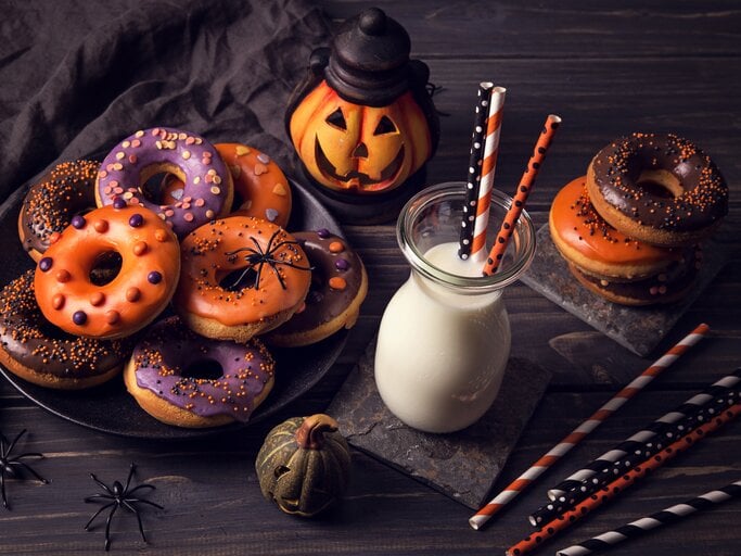 verschieden dekortierte Halloween-Donuts auf einem Teller.  | © iStock / egal