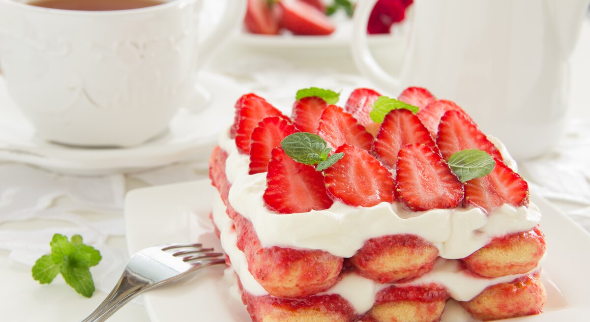 Geschichtetes Erdbeer-Tiramisu mit frischen Früchten, Creme und Biskuit.