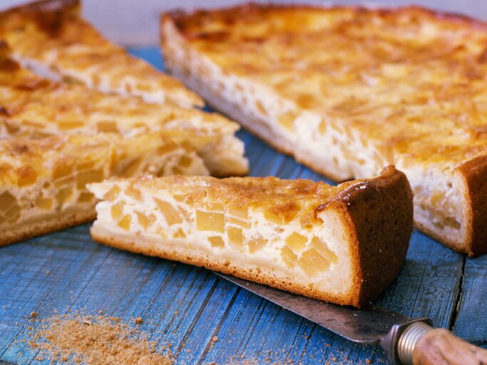 Einige Stücken vom hesssischen Schmandkuchen auf einem blauen Holztisch. | © StockFood / Hoffmann, Matthias