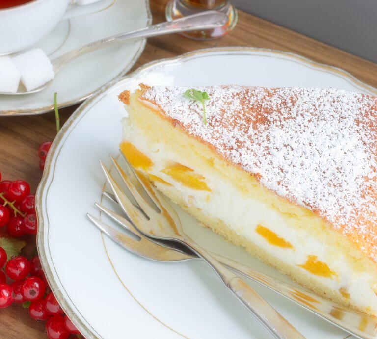 Sieht super aus, ist schnell gemacht und schmeckt einfach köstlich: Schmandtorte mit Biskuitteig und Pfirsich.  | © iStock/ Atide