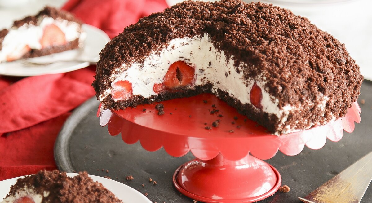 angeschnittener Maulwurfkuchen mit Erdbeeren auf einer Etagere. 