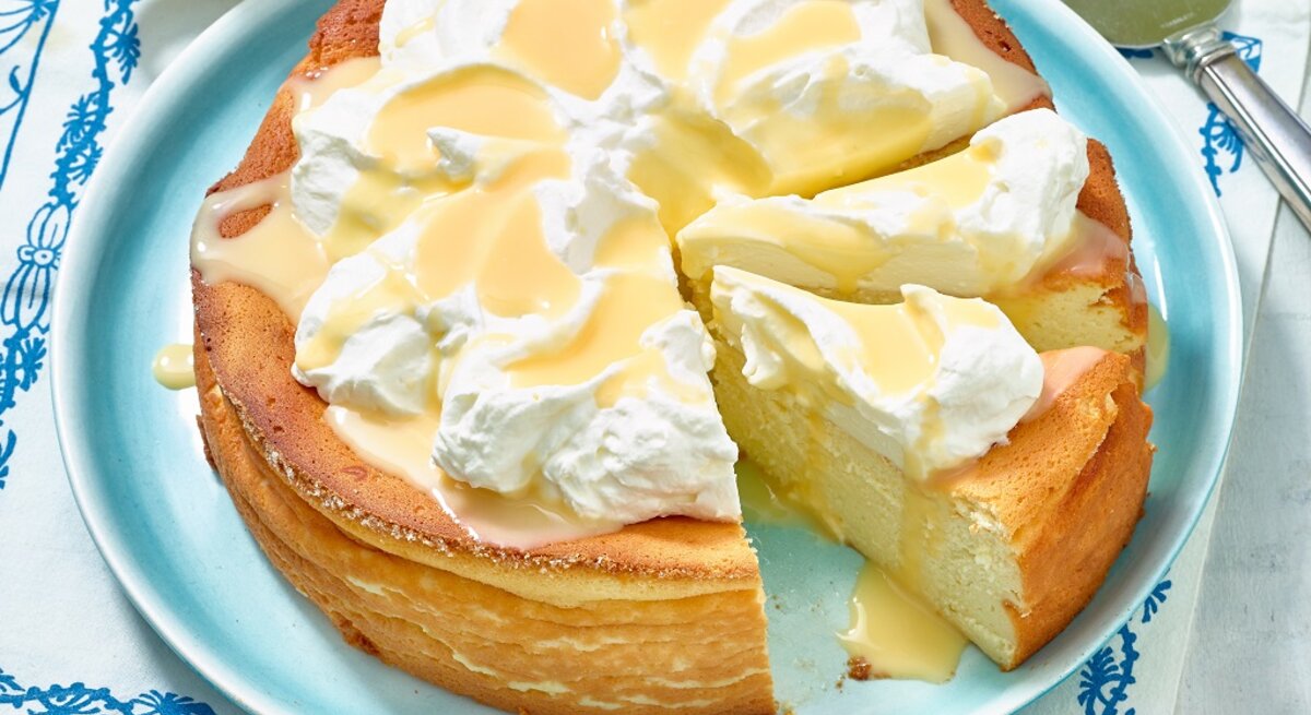 Der Eierlikör-Käsekuchen von schräg oben auf einem hellblauen Teller fotografiert.