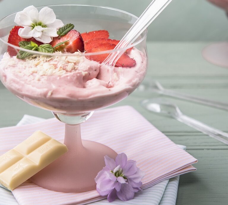 Draufsicht, eint schräg von oben: Eine weiße Schokoladenmousse mit Mascarpone und Erdbeeren in einem Glas. | © StockFood / Hendey, Magdalena