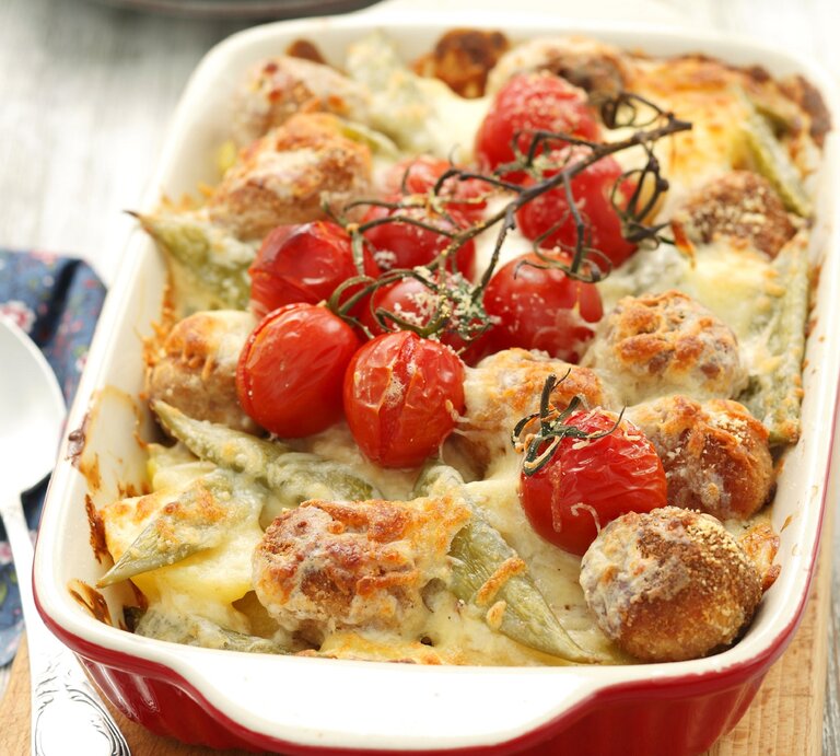 Kartoffelauflauf mit Hackbällchen und Tomaten in weißer Auflaufform.  | © StockFood