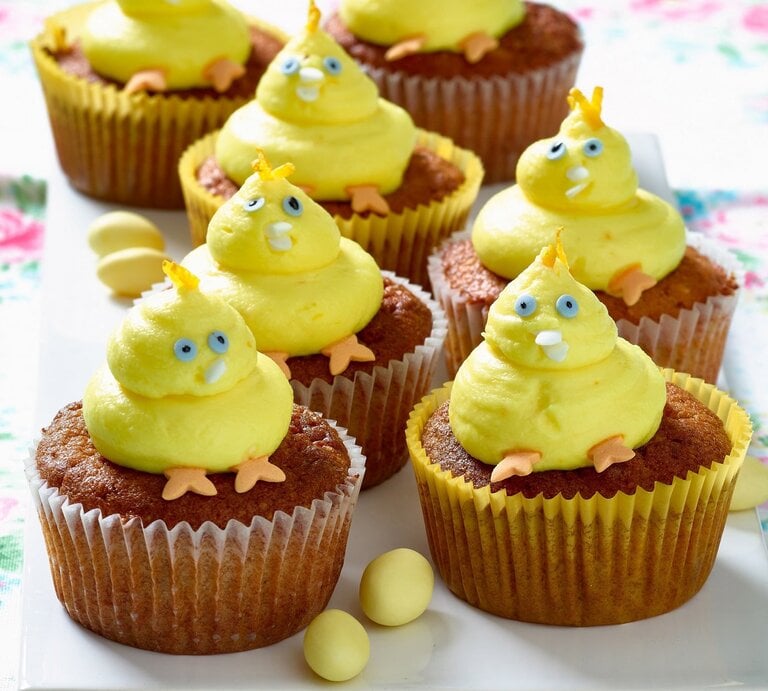 Gelbe Küken-Cupcakes mit blauen Augen und orangen Füßen auf einer Etagere. | © Matthias Liebich