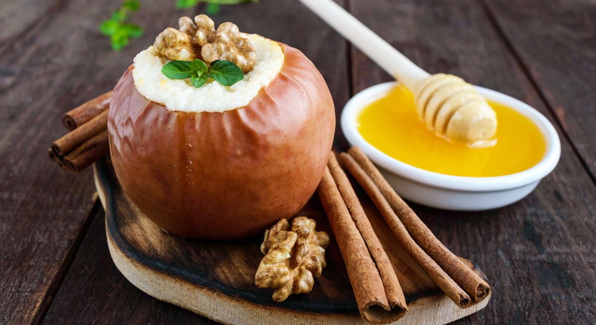 Bratapfel-Mousse mit Vanillesoße in einem Bratapfel / Zimstangen / Walnusskerne
