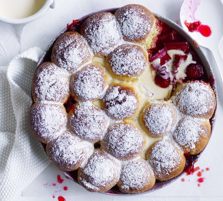 Draufsicht: Ein Rhabarber-Erdbeer-Dessert mit Milchbrötchen und Vanillesoße in einer runden Form aus Metall. | © StockFood / Bauer Syndication