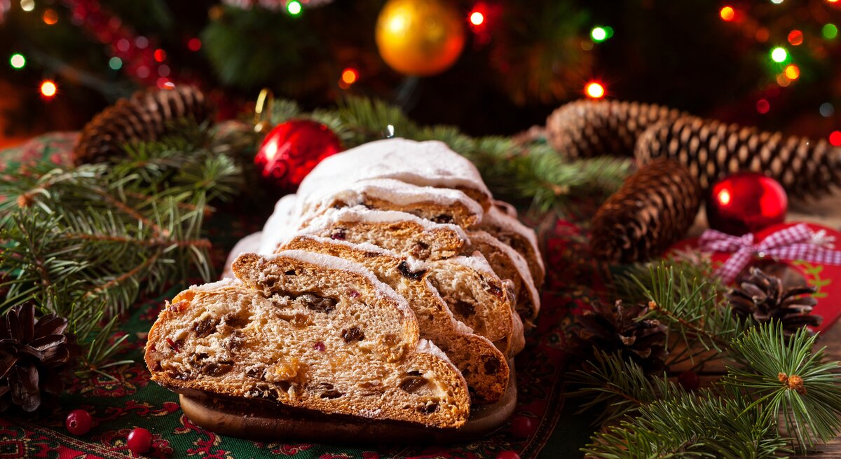 Ein angeschnittener Stollen umringt von vielen weihnachtlichen Deko-Elementen. 