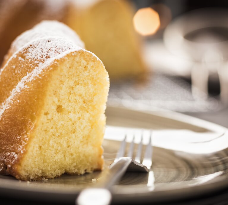 Angeschnittener Sandkuchen mit Puderzucker.  | © iStock/ GMVozd