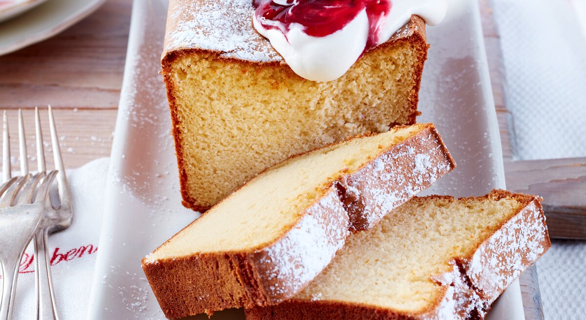 Marzipan-Kuchen mit Schlagsahne und roter Grütze.
