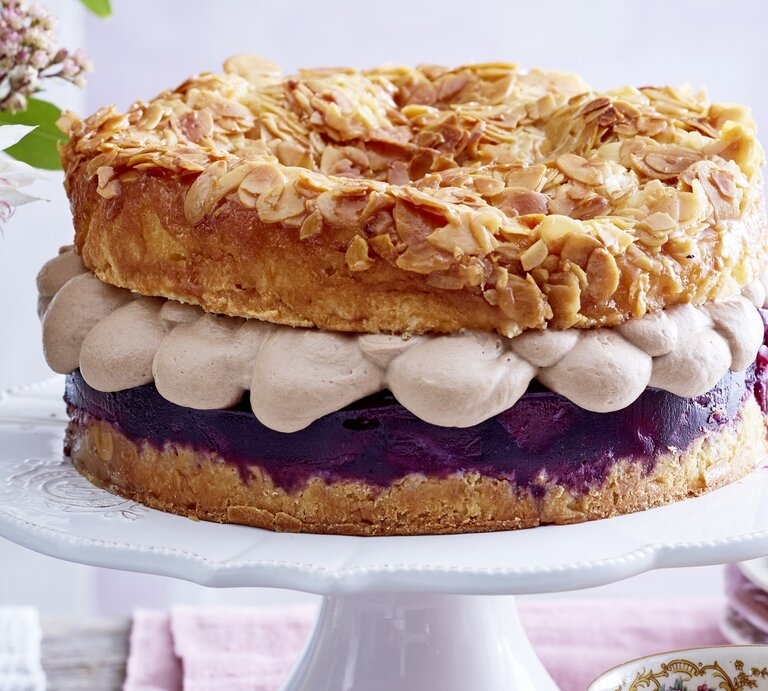 Frontal fotografierter Bienenstich mit Nougatsahne und Rotwein-Birnenkompott auf einer Etagere. | © EAT CLUB/Isabell Triemer