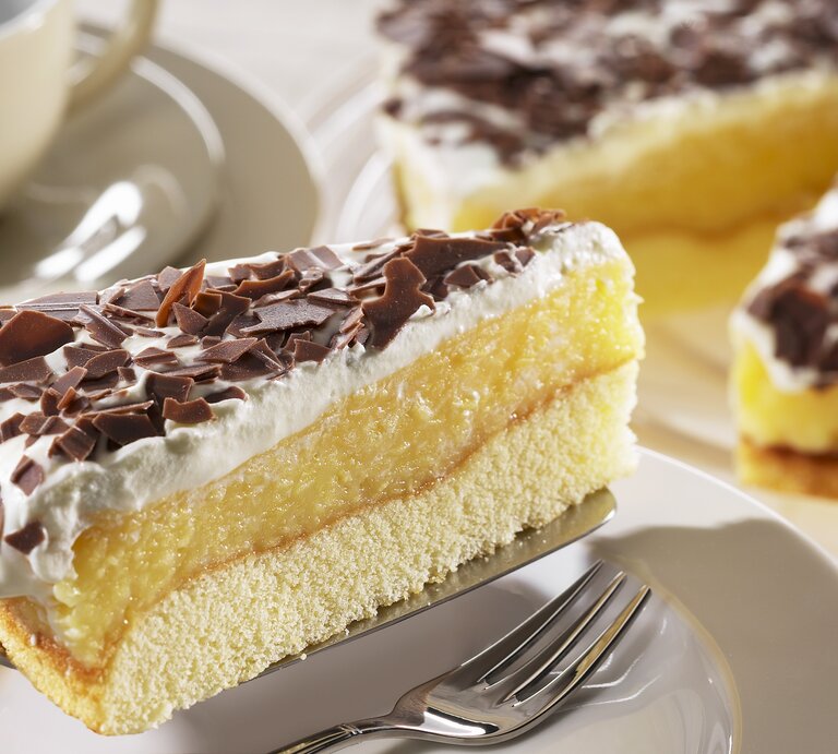 Ein Stück der schwedische Apfeltorte mit Sahne und Schokoraspeln auf einem Kuchenteller von schräg oben fotografiert.  | © StockFood / FoodFoto Köln