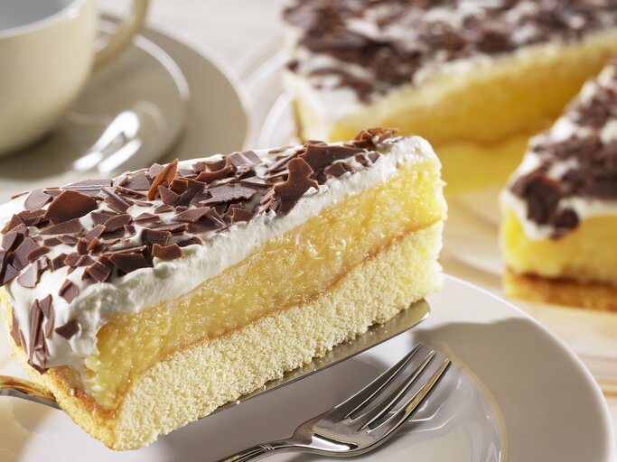 Ein Stück der schwedische Apfeltorte mit Sahne und Schokoraspeln auf einem Kuchenteller von schräg oben fotografiert.  | © StockFood / FoodFoto Köln
