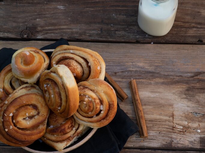 Mehrere schwedische Zimtschnecken in rustikalem Ambiente. | © iStock/Sarah Biesinger