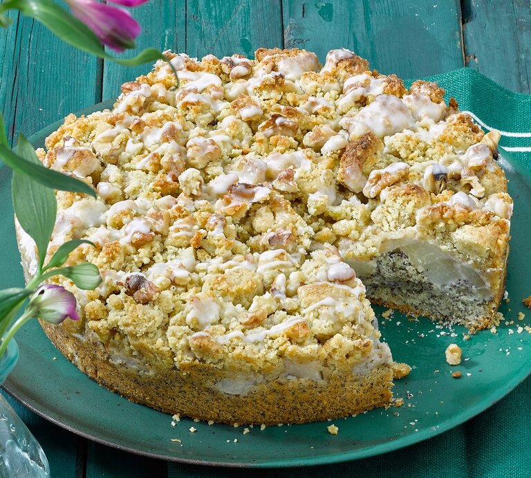 Der Mohnkuchen auf einem türkisenen Teller und türkisen Holztisch. Alles von der Seite fotografiert. | © Matthias Liebich