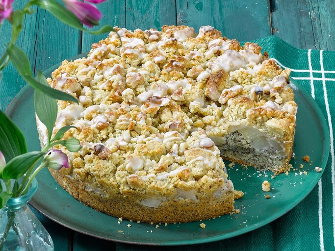 Der Mohnkuchen auf einem türkisenen Teller und türkisen Holztisch. Alles von der Seite fotografiert. | © Matthias Liebich