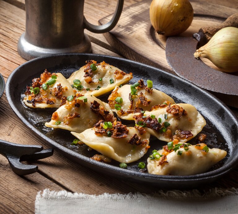 Mehrere Pierogi auf einem teller.  | © iStock/arfo