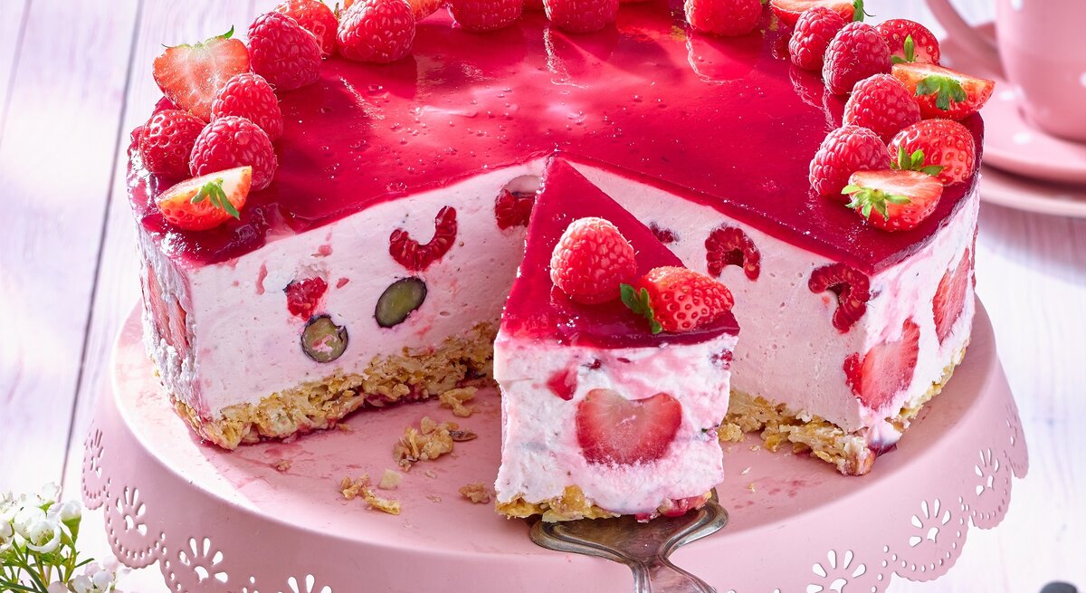 Beeren-Quark-Torte auf einem rosa Tortenteller. 