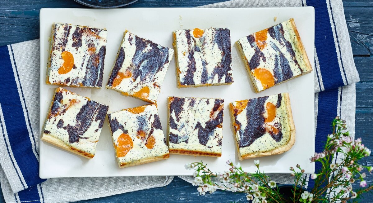 Mehrere viereckige Stücke Mohn-Käsekuchen in der Draufsicht. 