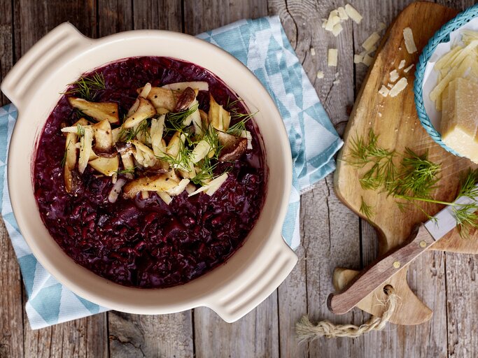 Rote Bete Risotto auf hölzernem Hintergrund. Rechts davon Parmesan. | © StockFood/Eat Club; Isabell Triemer