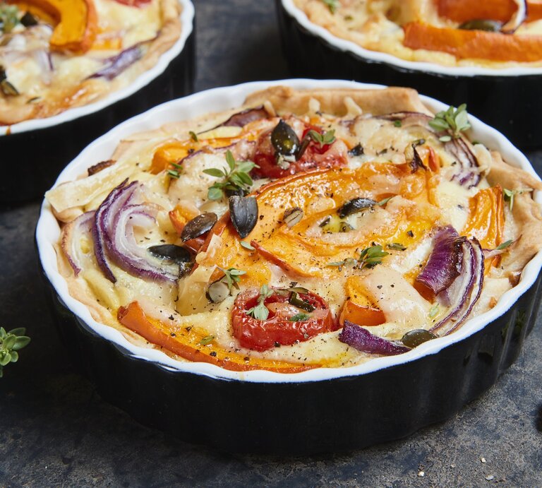 Die Kürbis-Quiche mit roten Zwiebeln in einer schwarzen Auflaufform gebacken. | © StockFood / Sporrer, Brigitte