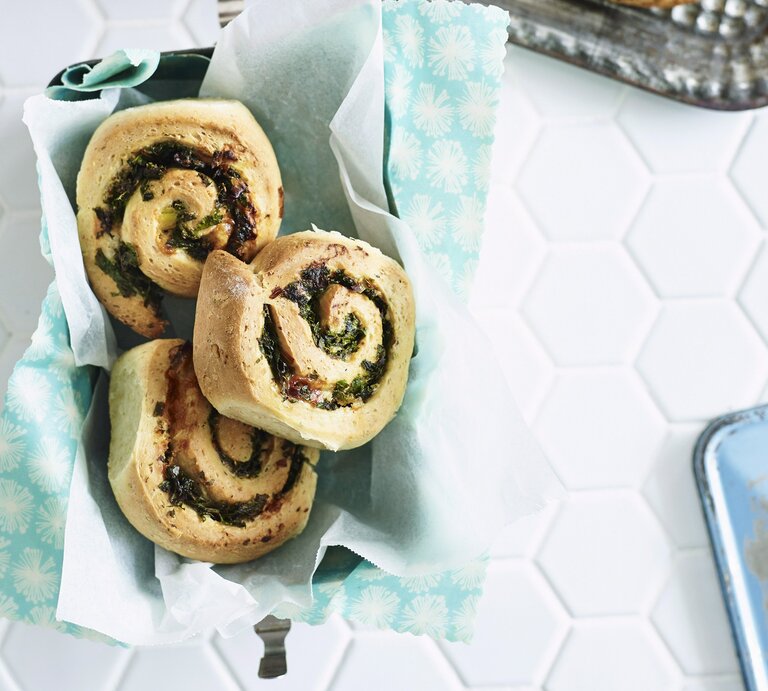 Mehrere Käse-Grünkohl-Schnecken in einem Korb, der mit einem Tuch ausgeschlagen ist. | © StockFood / Bauer Syndication