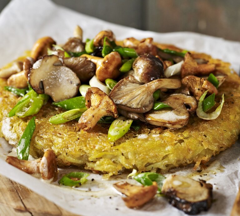Ein Kartoffelrösti mit gemischten Pilzen auf Papier | © StockFood/Brachat, Oliver