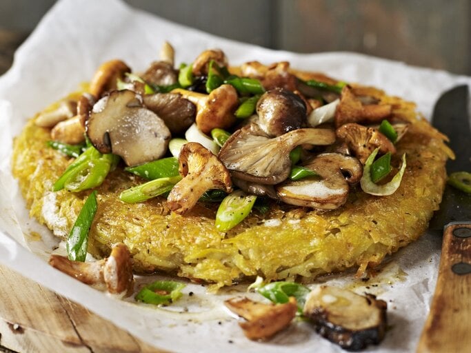 Ein Kartoffelrösti mit gemischten Pilzen auf Papier | © StockFood/Brachat, Oliver