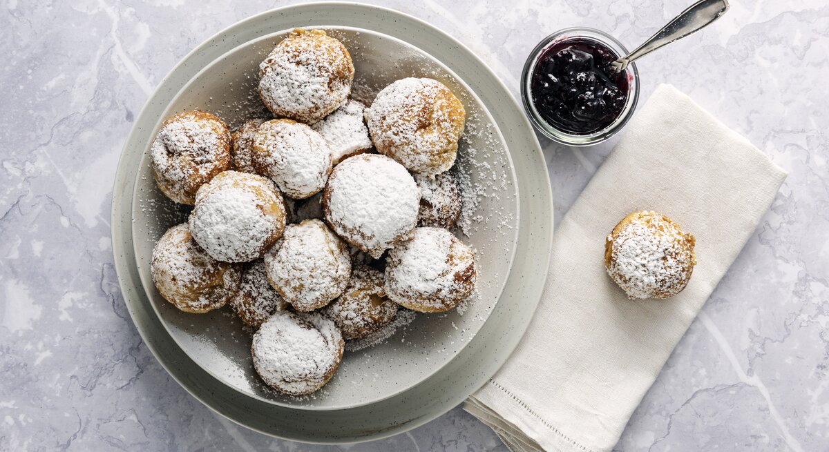 Runde Pfannkuchen mit Puderzucker auf weißem Untergrund. 
