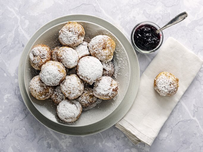 Runde Pfannkuchen mit Puderzucker auf weißem Untergrund.  | © Getty Images/ClarkandCompany