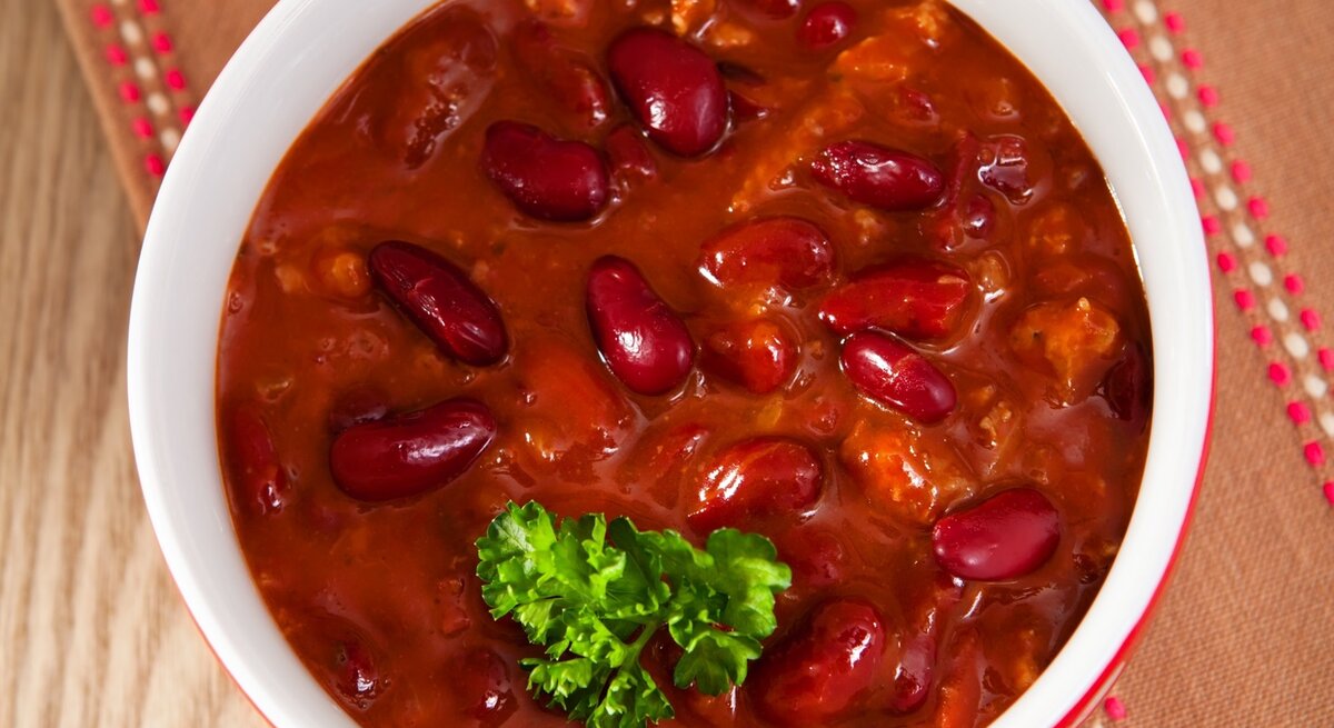 Die Mitternachtssuppe auf einem Holztisch nah und direkt von oben fotografiert.
