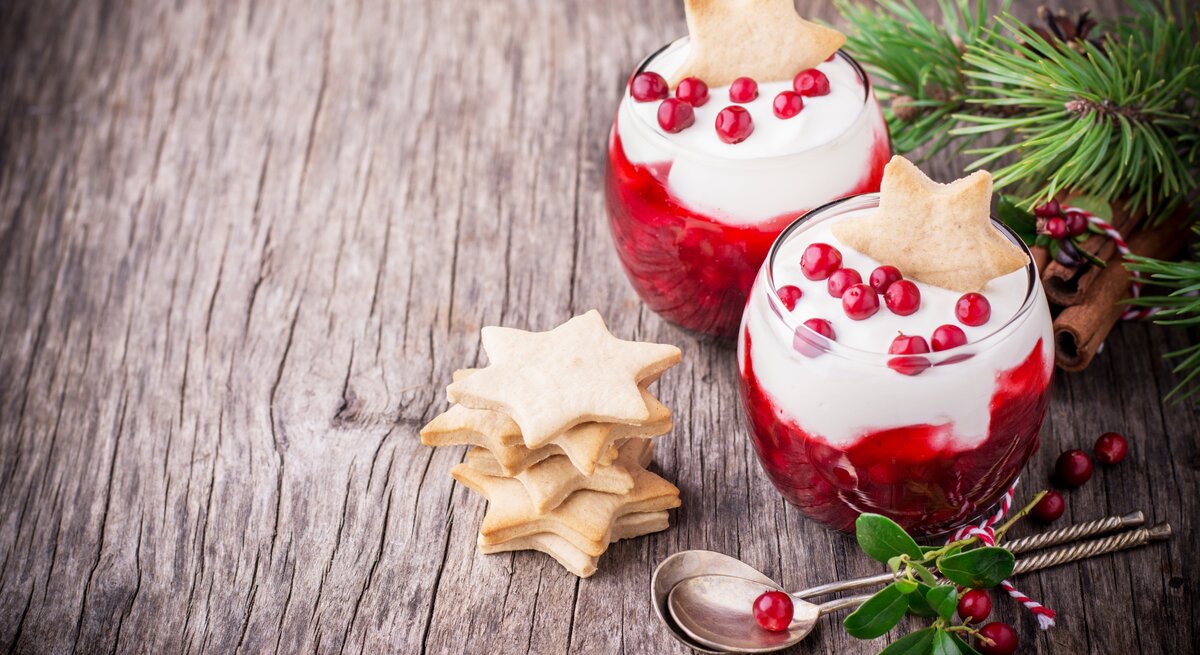 Weihnachtlich dekoriertes Dessert im Glas auf Holztisch. 