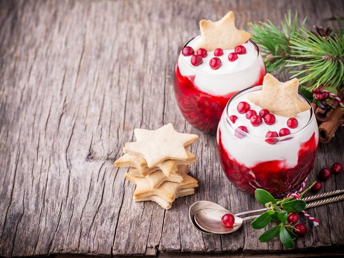 Weihnachtlich dekoriertes Dessert im Glas auf Holztisch.  | © Getty Images/AnnaIleysh