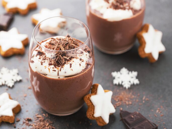 Weihnachtliche Schokoladen-Mousse im Glas, angerichtet mit Sahnecreme, Schokoraspel und Zimtsternen. | © iStock.com/nerudol