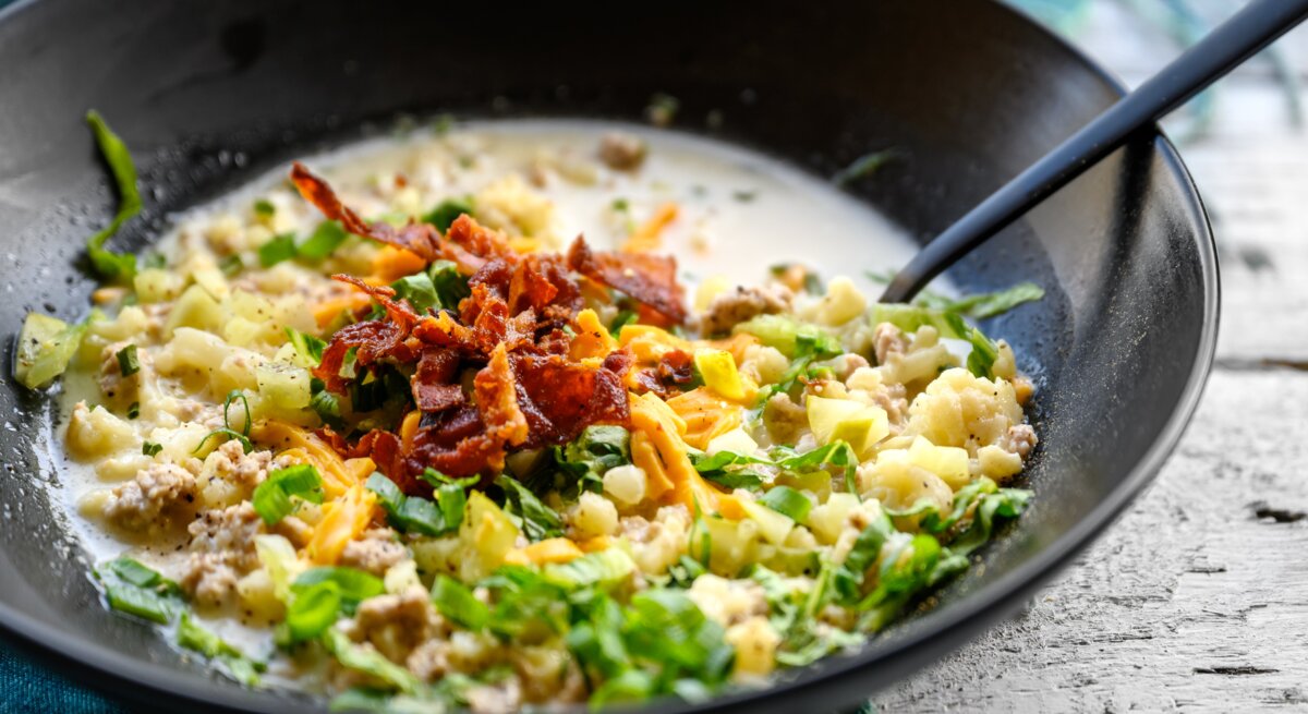 Hackfleisch, Bacon und Käse in Sahnesoße in einer Pfanne.