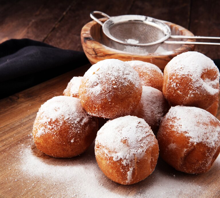 Mehrere mit Puderzucker bestäubte Quarkbällchen.  | © iStock/beats3