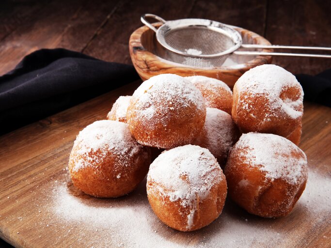 Mehrere mit Puderzucker bestäubte Quarkbällchen.  | © iStock/beats3