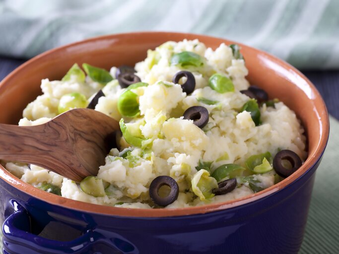 Tonschale gefüllt mit Kartoffelpüree mit Oliven und Rosenkohl. | © iStock.com/cheche22