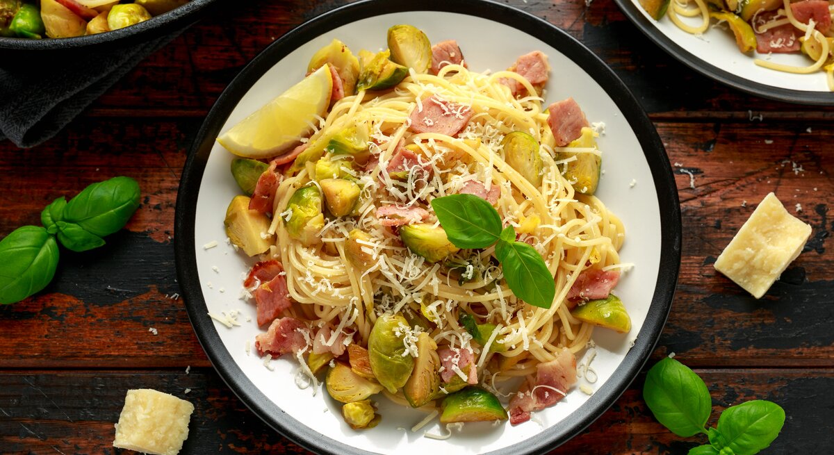 Draufsicht auf einen Teller mit Carbonara mit Rosenkohl.