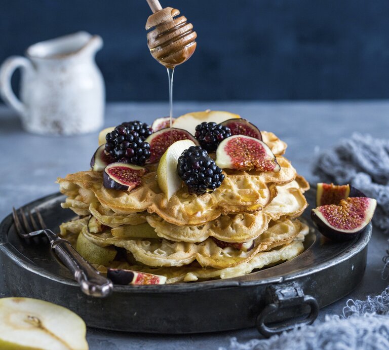Die Joghurt Waffeln auf einem schwarzen Teller mit grauem Hintergrund. Alles von der Seite fotografiert. | © StockFood / Takacs, Aniko