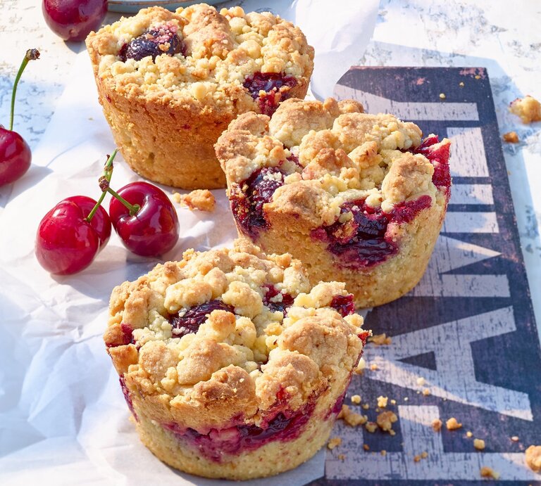 Schräge Draufsicht auf Kirsch-Muffins mit Streuseln | © Matthias Liebich