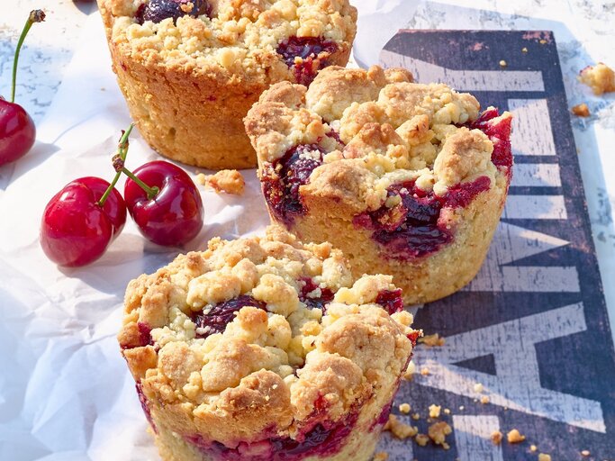 Schräge Draufsicht auf Kirsch-Muffins mit Streuseln | © Matthias Liebich