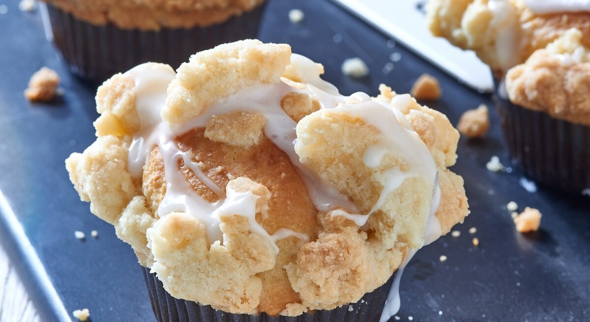 Muffins mit Streuseln auf einem blauen Untergrund.