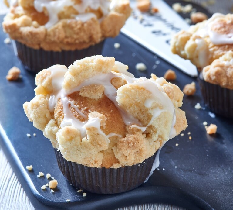 Muffins mit Streuseln auf einem blauen Untergrund. | © Shutterstock/ Lynne Ann Mitchell