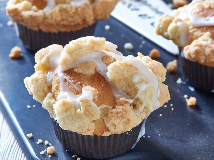 Muffins mit Streuseln auf einem blauen Untergrund. | © Shutterstock/ Lynne Ann Mitchell