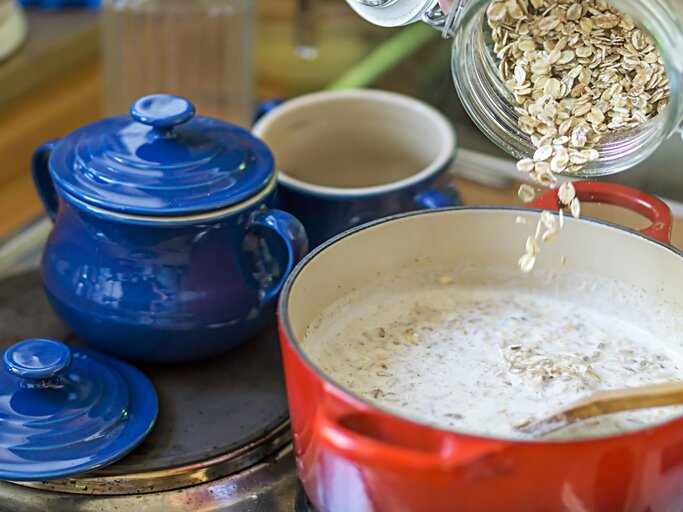 Ein roter Topf mit der Haferflocken Suppe auf einer Küchenzeile. | © iStock/Thomas Demarczyk