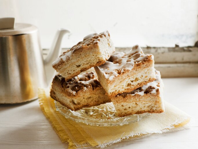 Mehrere Kuchenstücke auf einem hellen Kaffeetisch mit Kanne im Hintergrund. | © StockFood/Löscher, Sabine